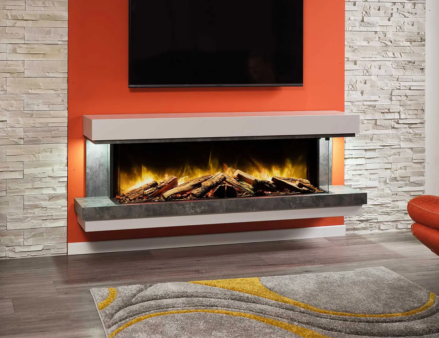 Wall-mounted electric fireplace mounted on an orange wall below a turned off television