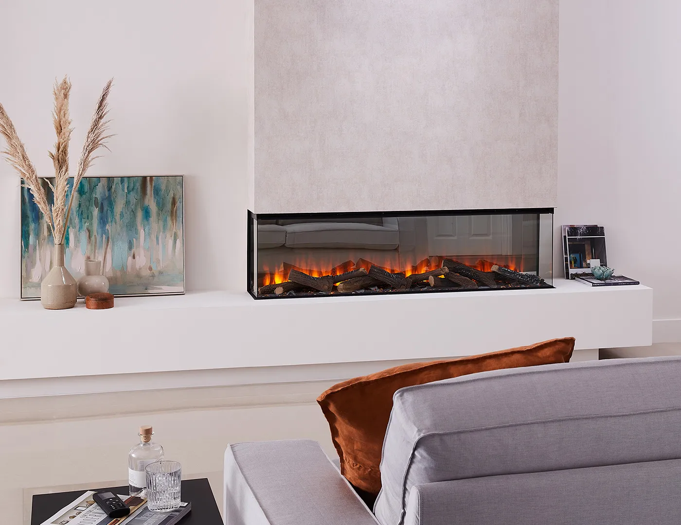 Electric fireplace built into a wall, in a living room, with the flames visbile from three sides