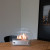 Circular tabletop fireplace wit glass panels on the sides