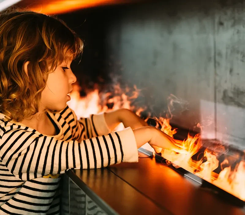 Water vapour Opti-myst fireplace with a little girl placing her fingers into the real-life flame